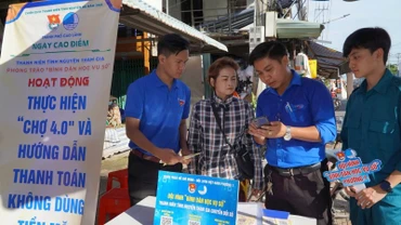 Đoàn viên hướng dẫn tiểu thương thanh toán không dùng tiền mặt tại chợ Mỹ Ngãi, Phường 1, thành phố Cao Lãnh.