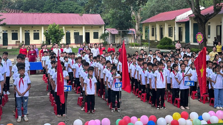 Giáo viên, học sinh Trường Tiểu học và trung học cơ sở Tân Sơn, xã Tân Kỳ chào cờ trong lễ khai giảng. (Ảnh: TUẤN SƠN) 14-1174.jpg
