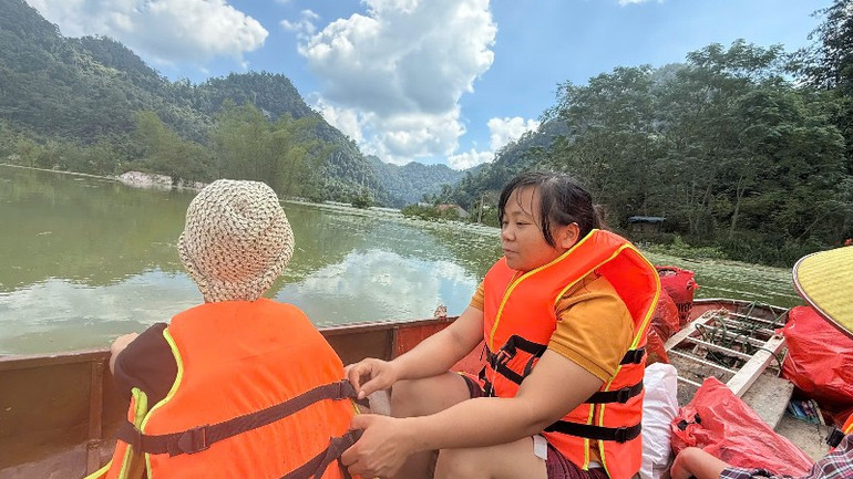 Phụ nữ và trẻ nhỏ thôn Kim Vân trên xuồng di dời tới nơi cao ráo tránh nước ngập. (Ảnh: TUẤN SƠN). 33-8892.jpg