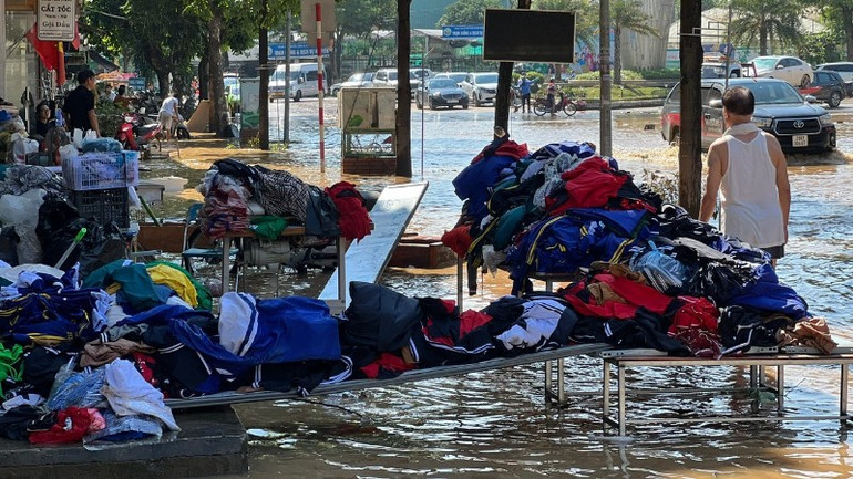 As soon as the water receded from their houses, clothing vendors on Luong Ngoc Quyen Street set up tables and chairs to temporarily dry their goods. (Photo: TUAN SON). 18-8928.jpg