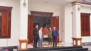 Cán bộ NHCSXH huyện Quỳ Hợp mừng nhà mới gia đình anh Bùi Đức Kiên ở Khối 11, thị trấn Quỳ Hợp, được vay vốn của NHCSXH làm nhà ở theo Quyết định 100/CP.