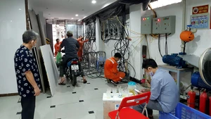 Nhân viên điện lực lắp đặt đồng hồ ở một chung cư mini trên địa bàn quận Ðống Ða.