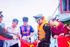 Cán bộ, chiến sĩ Hải đoàn 48 và Bộ Tư lệnh Vùng Cảnh sát biển 2 tặng cờ Tổ quốc cho ngư dân.