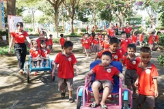 Giáo viên mầm non cùng các bé trong một buổi hoạt động ngoài trời.