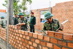 Giúp dân vùng lũ phường Đông Hòa, tỉnh Đắk Lắk xây dựng nhà mới sau thiên tai. Ảnh: Tuyên huấn Quân khu 5 cung cấp