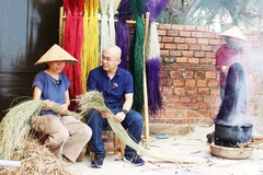 Anh Huy đang trao đổi câu chuyện với chị Phạm Thị Công về nghề dệt chiếu.