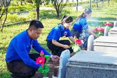 Thay mới cành sen, lọ hoa và thắp hương tại các ngôi mộ liệt sĩ.