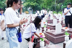 Thanh niên kiều bào thắp hương tưởng nhớ các anh hùng liệt sĩ tại Nghĩa trang Trường Sơn. Ảnh: NVNONN