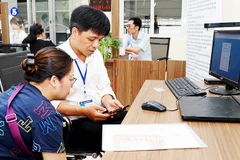 Hướng dẫn người dân sử dụng VNeID để làm thủ tục hành chính tại phường, xã. Ảnh: BẮC SƠN