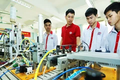 Thầy Cao Hồng Long, (áo sẫm) Trường cao đẳng nghề Công nghệ cao Hà Nội, giới thiệu mô hình tự động hóa cho sinh viên Lớp điện tử công nghiệp K13.