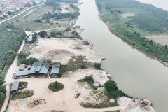 Cụm bến bãi tập kết cát nằm sâu trong một nhánh sông Hồng thuộc Công ty Cổ phần Thương binh Thành Luân, tách biệt khu dân cư, các mố cầu cảng được đắp dựng vươn ra sông để phục vụ việc vận chuyển cát từ dưới sông lên bãi. Ảnh chụp ngày 28/12/2025.