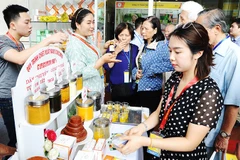 Doanh nghiệp giới thiệu sản phẩm được chiết xuất từ nghệ tại triển lãm y - dược. Ảnh: NAM ANH