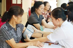 Khám sức khỏe định kỳ cho người dân tại Trạm Y tế phường Nghĩa Đô. Ảnh: HẢI NAM