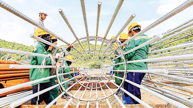 Kỹ sư và công nhân gia công lồng thép cọc khoan nhồi trên bãi đúc.