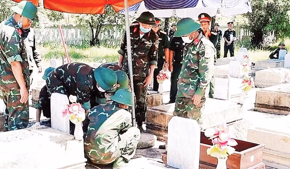 Tổ công tác tiến hành khai quật phần mộ để lấy mẫu hài cốt liệt sĩ tại phường Phong Điền (Ảnh LÊ SÁU)