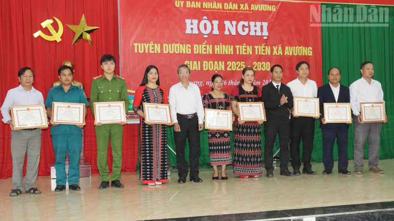 Chị Bnướch Thị Blắc (thứ 6 từ phải qua) và anh Alăng Bia (bìa phải) nhận giấy khen của Ủy ban nhân dân xã Avương. (Ảnh: Hiền Thúy). ndo_tr_33.jpg