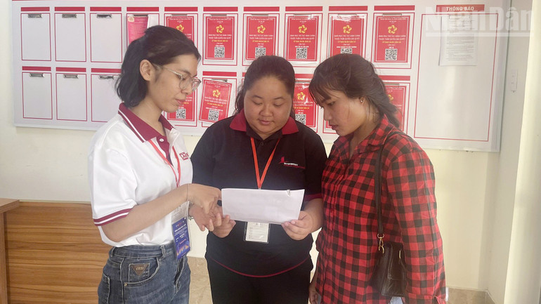 Ngọc Ánh và Hồng Ngọc (bên trái) hướng dẫn người dân về các bước thủ tục hành chính. ndo_tr_a1.jpg