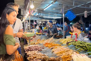 Ảnh minh họa: Khách du lịch nước ngoài hào hứng khám phá các món ăn Lào. (Ảnh: TRỊNH DŨNG)