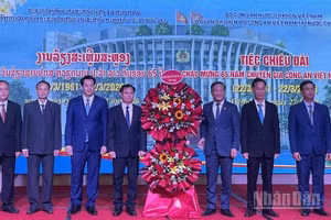 Đại sứ Nguyễn Minh Tâm (thứ 3 từ phải qua) tặng hoa chúc mừng đội ngũ Chuyên gia Công an Việt Nam tại Lào. (Ảnh: DUY TOÀN)