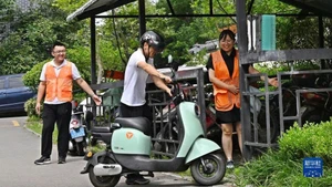 Nhân viên hướng dẫn người dân đưa xe điện vào điểm sạc pin tập trung ở thành phố Giao Châu, Thanh Đảo, tỉnh Sơn Đông, Trung Quốc. (Ảnh: Tân Hoa xã)