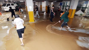 Người dân dọn nước lũ tại một cơ sở y tế ở tỉnh Jeolla Nam, Hàn Quốc, ngày 4/8/2025. (Ảnh: Yonhap/TTXVN)