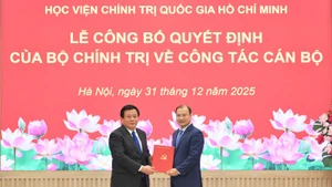 Đồng chí Nguyễn Xuân Thắng, Ủy viên Bộ Chính trị, Giám đốc Học viện Chính trị quốc gia Hồ Chí Minh, Chủ tịch Hội đồng Lý luận Trung ương, trao quyết định của Bộ Chính trị và chúc mừng đồng chí Lê Hải Bình, Ủy viên dự khuyết Trung ương Đảng, Phó Giám đốc Học viện Chính trị quốc gia Hồ Chí Minh. (Ảnh: THẾ ĐẠI)