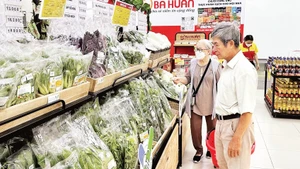Người tiêu dùng chọn mua rau sạch đạt chứng nhận “Tick xanh trách nhiệm” trong một siêu thị SatraMart ở thành phố.