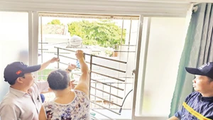 Cán bộ cơ quan chức năng phường Bình Quới thực hiện tháo gỡ “chuồng cọp” tại một hộ dân ở chung cư Thanh Đa.