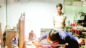Ông Nguyễn Văn Kiệt quan sát thợ hàn thực hiện công đoạn hoàn thiện sản phẩm.
