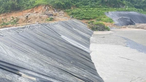 Thân đập hồ chứa bùn thải quặng đuôi số 1 đã được gia cố, lót bạt. (Ảnh: TUẤN SƠN)