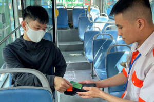 Hành khách thanh toán không dùng tiền mặt khi đi một số tuyến xe buýt của thành phố. (Ảnh: QUÝ HIỀN)