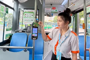 Nhân viên phục vụ hướng dẫn hành khách cài đặt ứng dụng MultiGo và các phương thức thanh toán điện tử. Tuy nhiên, trong thời gian từ ngày 1/7 đến cuối tháng 9 thành phố chưa kiểm tra các giấy tờ tùy thân. (Ảnh: QUÝ HIỀN)