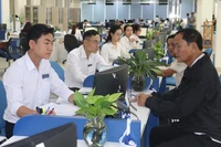 Cán bộ tại bộ phận một cửa Ủy ban nhân dân tỉnh Quảng Ngãi tiếp đón và giải quyết hồ sơ cho người dân. (Ảnh: HIỂN CỪ)