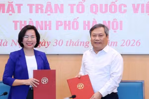 Chủ tịch Ủy ban nhân dân thành phố Hà Nội Vũ Đại Thắng trao biên bản bàn giao 18 hội cho Chủ tịch Ủy ban Mặt trận Tổ quốc Việt Nam thành phố Bùi Huyền Mai. (Ảnh: ĐÌNH HIỆP)