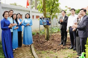 Các đại biểu tham gia trồng cây trong khuôn viên Nhà lưu niệm Lực lượng Nữ du kích Hoàng Ngân.