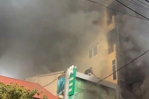 Một người mắc kẹt bị thương khi tự thoát ra ngoài được người dân hỗ trợ, giải cứu. (Ảnh: HQ)