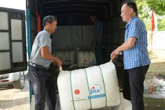 Lãnh đạo xã Hợp Thịnh hỗ trợ vận chuyển quà tặng về cho bà con các thôn. (Ảnh: MAI TOAN)