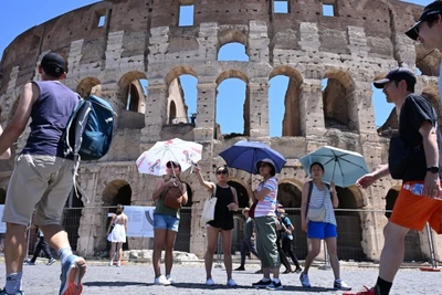 Khách du lịch che ô tránh nắng nóng khi tham quan Đấu trường La Mã ở Rome, Italia ngày 12/7/2024. (Ảnh: THX/TTXVN)