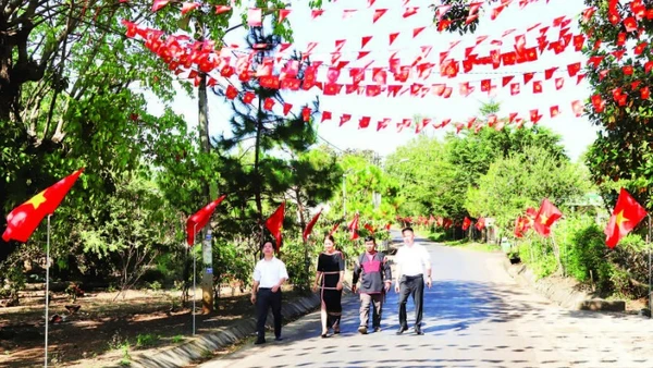 Các tuyến đường dẫn vào buôn Tuôr, xã Hòa Phú rợp đỏ màu cờ Tổ quốc chào mừng Đại hội XIV của Đảng.