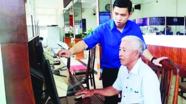 Chuyên viên Tổ công nghệ số cộng đồng phường Long An hướng dẫn người dân nộp hồ sơ trực tuyến tại Trung tâm hành chính công phường.