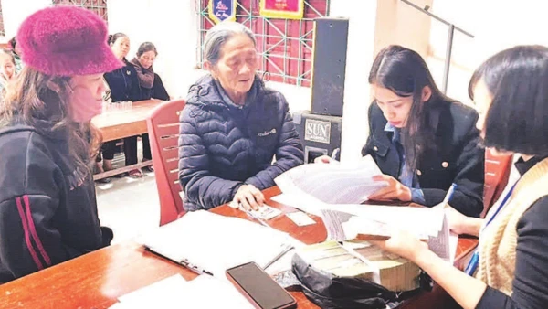 Cán bộ xã Tuyên Sơn, tỉnh Quảng Trị chi trả tiền quà Tết, tặng người dân.