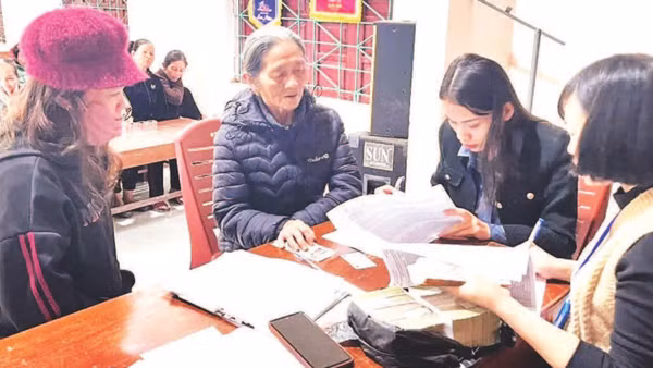 Cán bộ xã Tuyên Sơn, tỉnh Quảng Trị chi trả tiền quà Tết, tặng người dân.