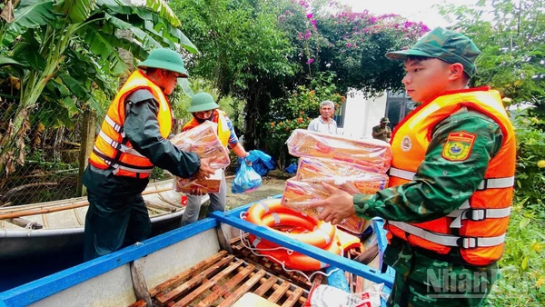 Cán bộ, chiến sĩ Đồn Biên phòng Bình Hải và Hải đội 2 (Bộ đội Biên phòng tỉnh Quảng Ngãi) vận chuyển nhu yếu phẩm hỗ trợ người dân thôn Châu Me, xã Đông Sơn.