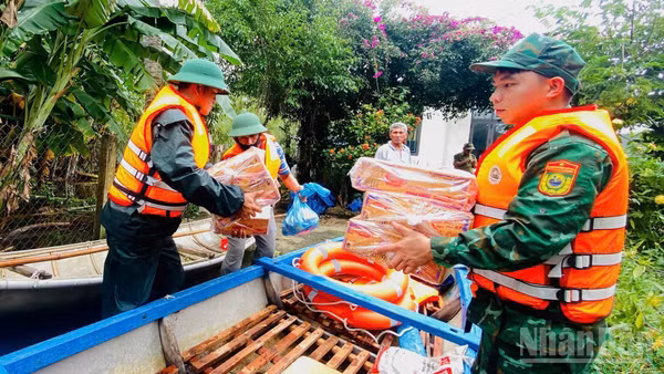 Cán bộ, chiến sĩ Đồn Biên phòng Bình Hải và Hải đội 2 (Bộ đội Biên phòng tỉnh Quảng Ngãi) vận chuyển nhu yếu phẩm hỗ trợ người dân thôn Châu Me, xã Đông Sơn.