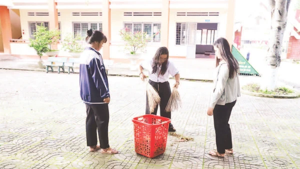 Học sinh Trường THPT Dân tộc nội trú Nơ Trang Lơng, tỉnh Đắk Lắk quét dọn vệ sinh khuôn viên nhà trường phòng chống dịch bệnh.