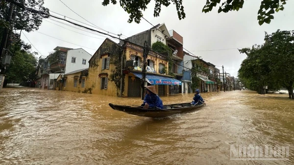 Nước ngập sâu, người dân sử dụng thuyền để di chuyển trong đô thị.