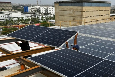 Các kỹ thuật viên lắp đặt tấm pin mặt trời trên mái nhà của một nhà máy ở thành phố cảng Karachi của Pakistan. Ảnh: AFP