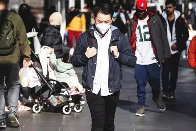 Duy trì thói quen đeo khẩu trang là biện pháp hữu ích phòng ngừa Covid-19. Ảnh: AAP