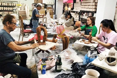 Các nghệ sĩ tạo hình tác phẩm mới trong không gian làng gốm cổ Bát Tràng. Ảnh: THỤY PHƯƠNG