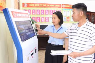 Công chức Trung tâm Phục vụ hành chính công xã Kim Thành, thành phố Hải Phòng, hướng dẫn người dân làm thủ tục hành chính. (Ảnh: TTXVN)